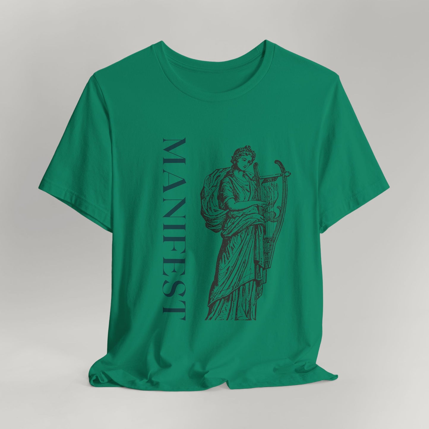 Green t-shirt with a graphic design and the word 'MANIFEST' on a gray background